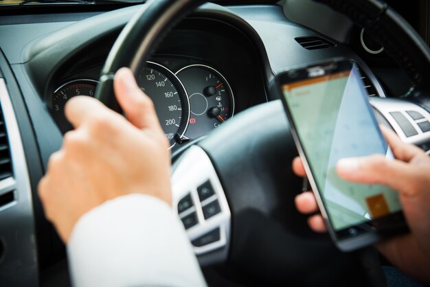 Photo businessman touching and using smartphone for online chat in front of steering wheel at front seat