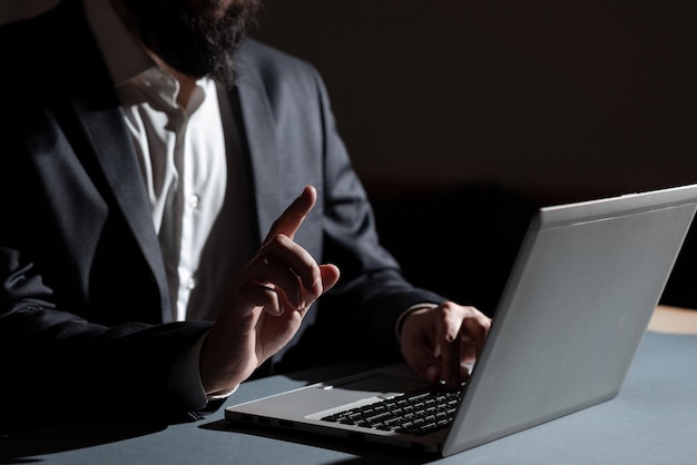 Businessman typing important informations into lap top and pointing new idea with one finger man