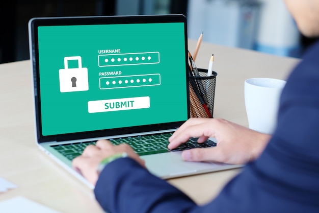 businessman typing password in the laptop