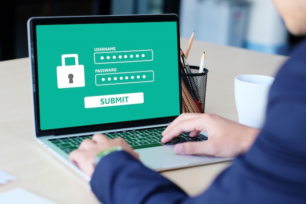 ノートパソコンでパスワードを入力する実業家