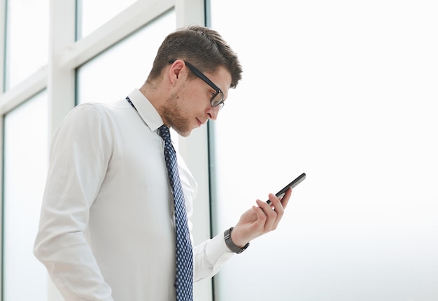 ビジネスマンはオフィスで電話と笑顔を使う