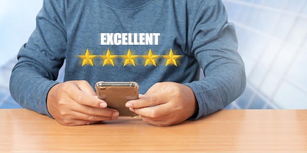 Businessman use smartphone choosing screen on five star icon to give satisfaction in service rating very impressed. Customer service experience. Concept of customer service and satisfaction.