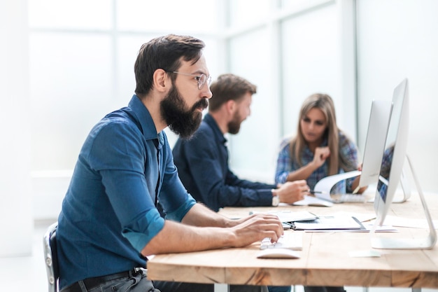 L'uomo d'affari utilizza un computer sul posto di lavoro in ufficio. persone e tecnologia