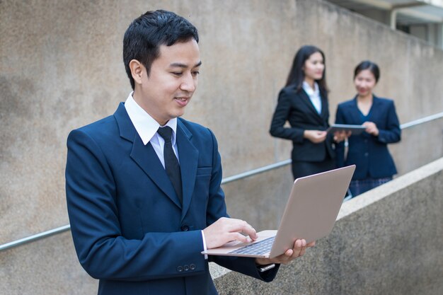 Businessman uses laptop outdoor