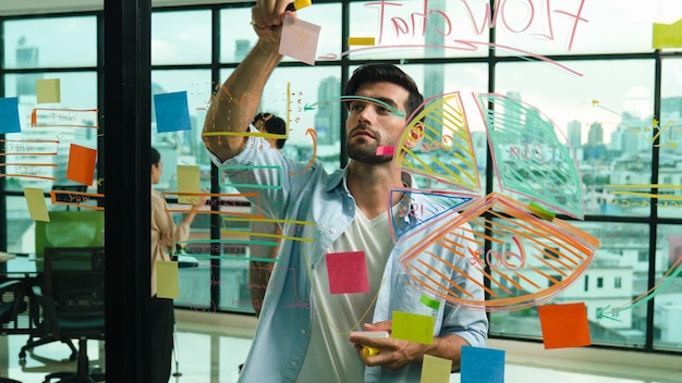 Businessman uses sticky notes at glass wall to brainstorming idea Tracery