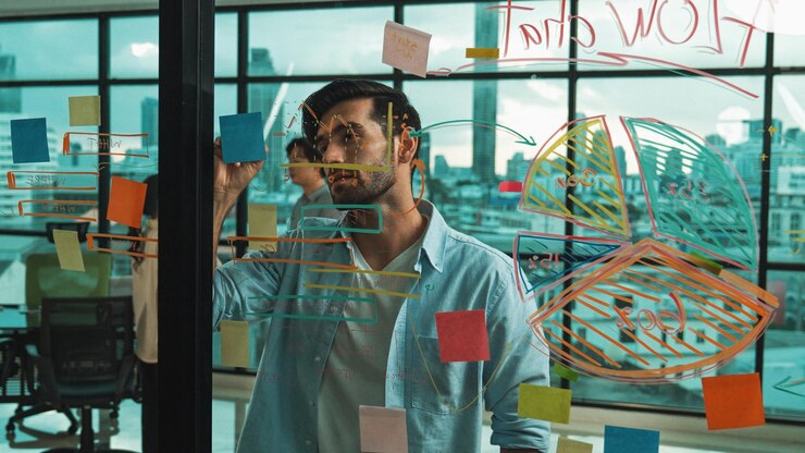 Photo businessman uses sticky notes at glass wall to brainstorming idea tracery