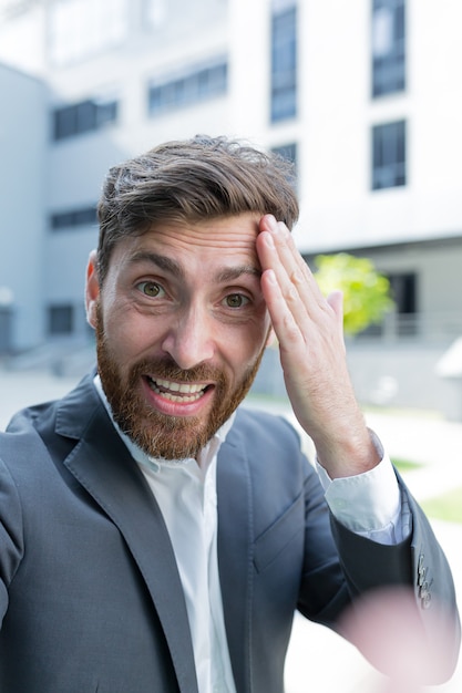 Foto l'uomo d'affari usa la videochiamata per conferenze e litigi seri, l'uomo urla ai dipendenti che guardano la fotocamera dello smartphone