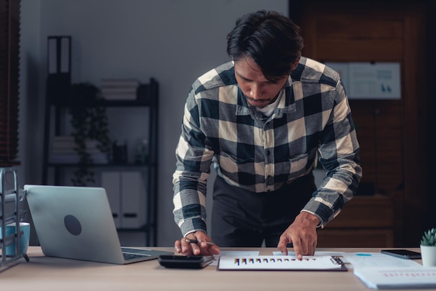 Photo businessman using calculator to checking financial and accounting report of business in office