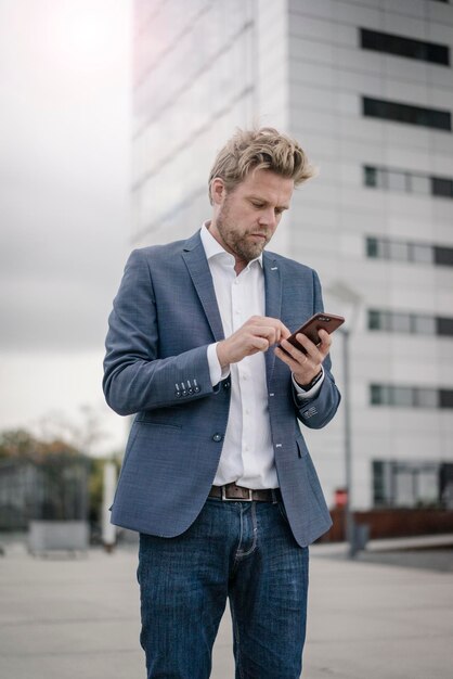 Businessman using cell phone in the city