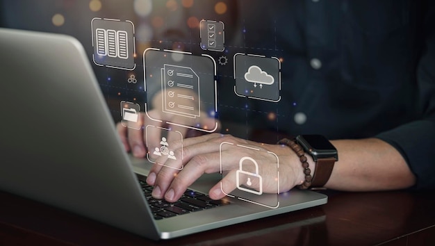 businessman using computer laptop to access global data network on interface organize a document database store digital data share data with a virtual interface