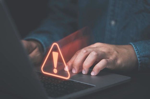 Photo businessman using computer laptop with red triangle caution warning sign for notification error and maintenance concept