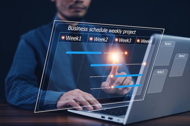 Businessman using computer for project business schedule by weekly Business plan management concept