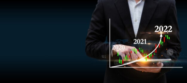 Businessman using digital mobile tablet with graphic candle stick population chart hologram on dark background, population community growth, stock market, investment and financial business concept