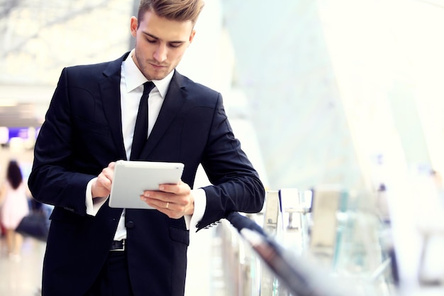 Businessman Using Digital Tablet In Airport Departure Lounge