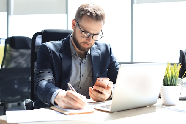 Businessman using his mobile phone in the office.