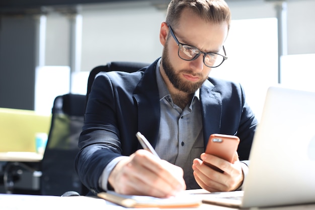 Businessman using his mobile phone in the office.