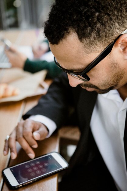 Businessman using his phone in a cafe