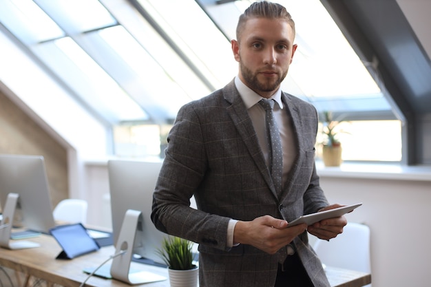 Foto uomo d'affari che utilizza il suo tablet in ufficio.