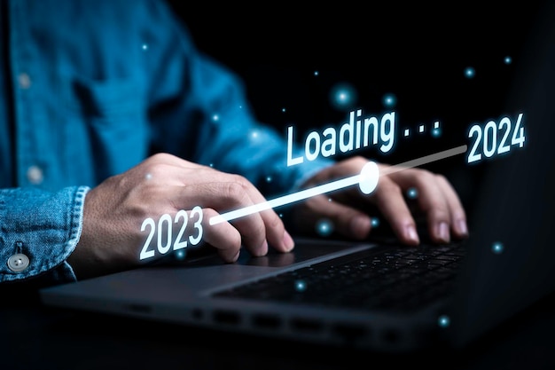 Photo businessman using laptop computer with downloading tool bar for countdown 2023 to 2024 merry christmas and happy new year preparation by technology concept