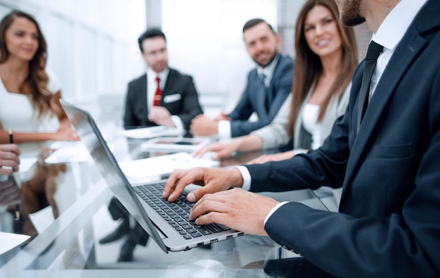 Businessman using laptop during a meeting of the board of directors