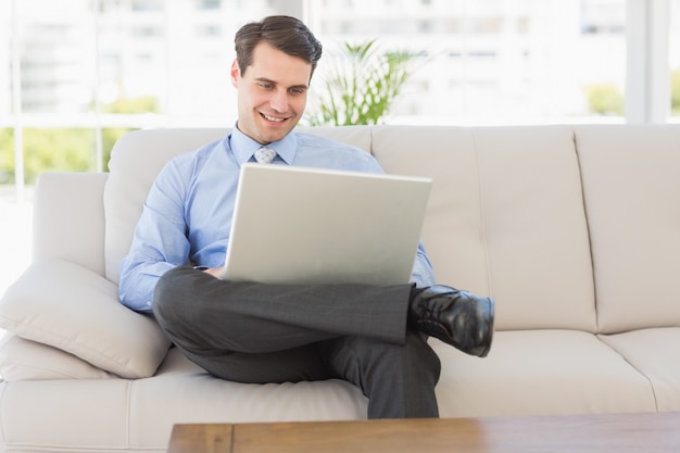 Businessman using laptop sitting on the couch