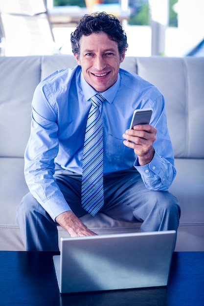 Foto uomo d'affari con laptop e smartphone