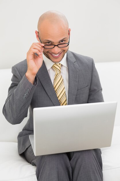 Businessman using laptop on sofa at home