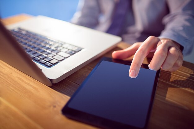 Foto uomo d'affari con laptop e tablet alla scrivania