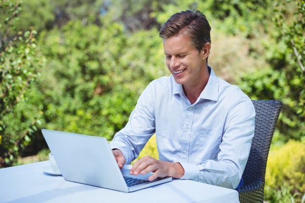 Businessman using laptop with coffee