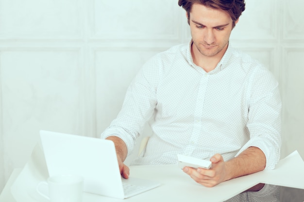 Businessman using laptop with tablet and pen