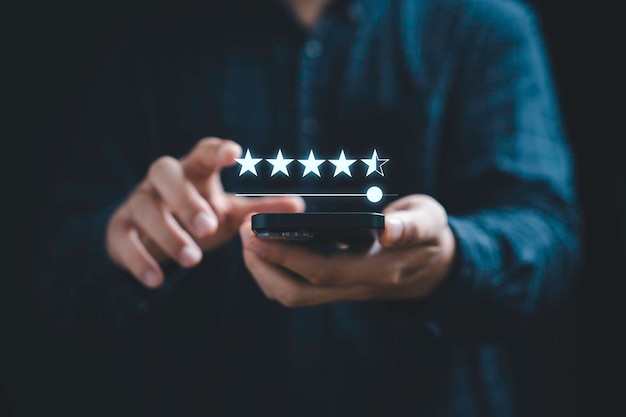 Businessman using mobile phone to give five stars for excellent evaluate after customer use product service ISO and quality standard certificate concept