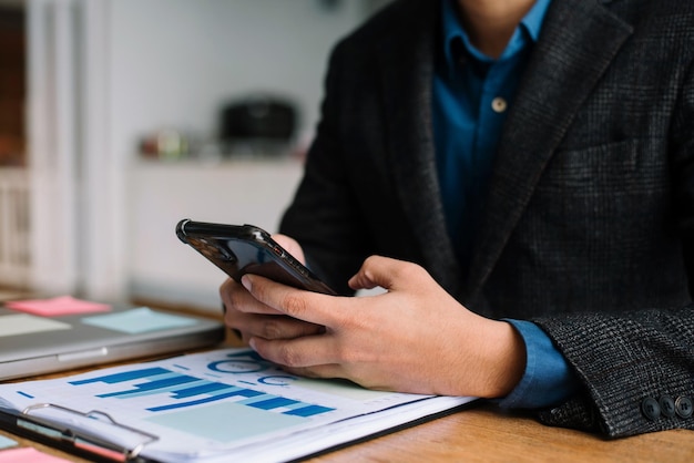 L'uomo d'affari che utilizza il telefono cellulare gioca sui social nella caffetteria