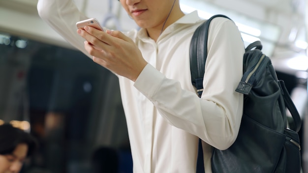 Businessman using mobile phone on public train