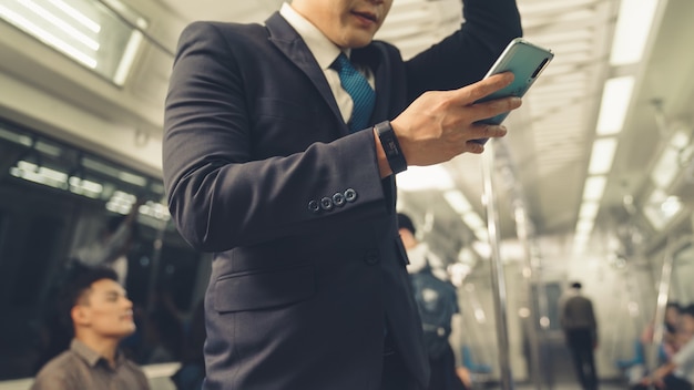 Businessman using mobile phone on public train