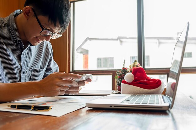 Photo businessman using mobile phone while sitting at desk