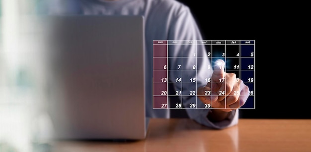 Photo businessman using pen to set meeting agenda on calendar as appointment planning concept