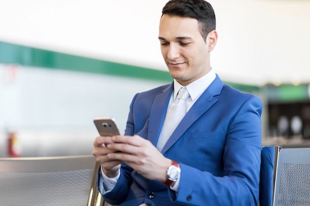 Businessman using the phone at the airport