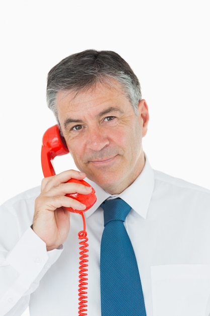 Businessman using red phone