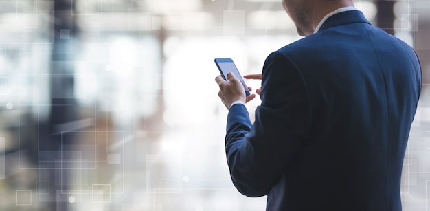 Businessman using smart phone on interior space