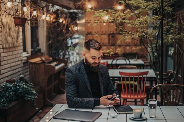 Foto uomo d'affari che utilizza lo smartphone in un caffè