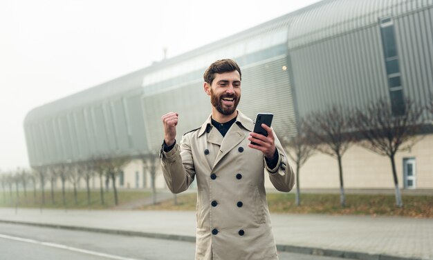 歩きながらスマートフォンを使用するビジネスマン