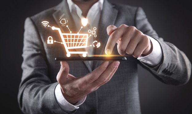 Businessman using smartphone with shopping cart. E-commerce. Online shopping
