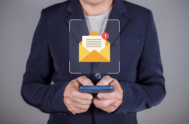 businessman using smartphone with virtual email icons for electronic mail or email with notification alert online communication email marketing newsletter