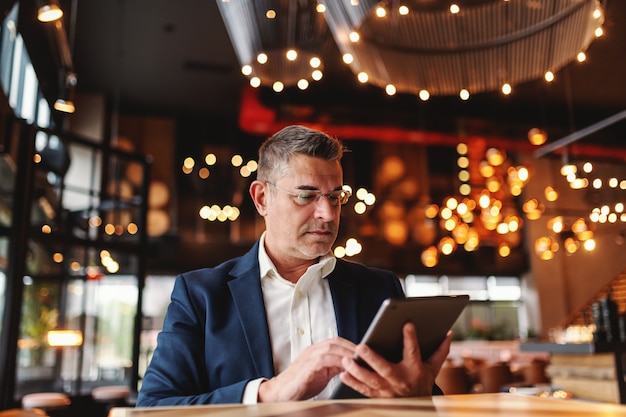 Businessman using tablet in cafe.