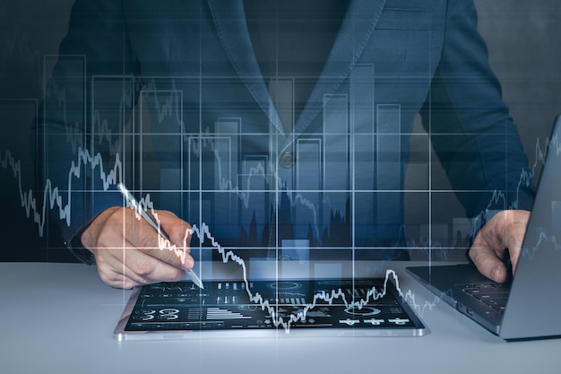 Uomo d'affari che utilizza tablet e laptop analizzando i dati di vendita e il grafico della crescita economica strategia aziendale marketing digitale statistiche e analisi grafiche per tablet e aziendali