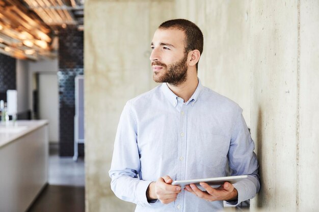 Foto uomo d'affari facendo uso della compressa in ufficio moderno