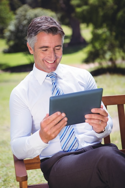 Businessman using tablet in the park