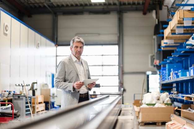 Businessman using tablet in production hall