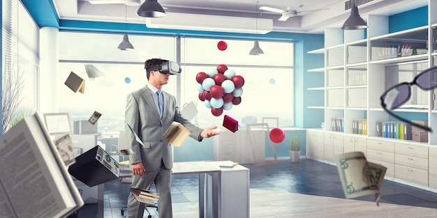 Businessman in VR headset with abstract bunch of spheres. Mixed media