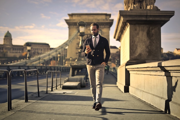 Foto uomo d'affari che cammina su un ponte